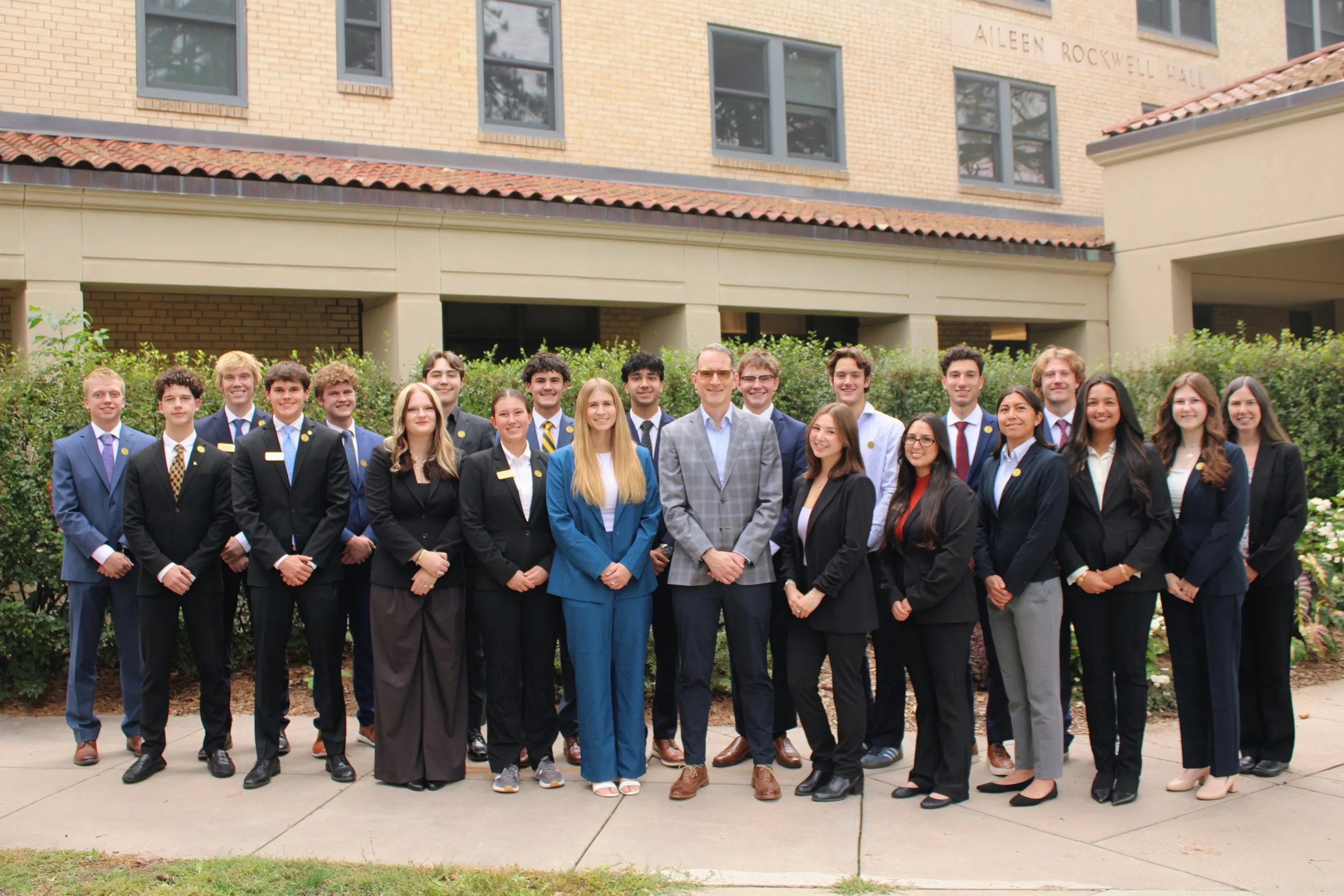 The Dean’s Student Leadership Council members standing together in front of the College of Business